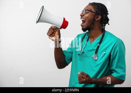 Young black doctor in green uniform using speaker. Stock Photo