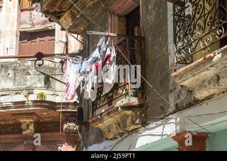 Clothesline in a balcony of a run-down residential building in the Cuban capital city. This is a traditional way of drying the laundry. The scene is c Stock Photo