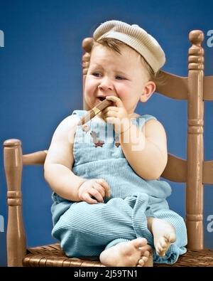 1940s BABY SITTING IN CHAIR HOLDING SMOKING CIGAR LOOKING VERY GANGSTER - b11108c HAR001 HARS CHARACTER VERY BIZARRE GUY WEIRD TOBACCO CIGARS GROTESQUE CHARACTERS CORDUROY LEADERSHIP ZANY UNCONVENTIONAL MOBSTER AUTHORITY BAD HABIT GANGSTER THUG WACKY IDIOSYNCRATIC ROLE PLAYING AMUSING ECCENTRIC FACIAL EXPRESSION HAT CAP JUVENILES SKEPTICAL TOUGH TOY CIGAR BABY GIRL CAUCASIAN ETHNICITY ERRATIC HAR001 OLD FASHIONED OUTRAGEOUS Stock Photo