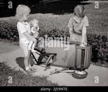 1960s BOY BROTHER FIXING REPAIRING TIRE WHEEL ON KID’S WAGON WHILE LITTLE GIRL SISTER CLUTCHING A DOLL WATCHES AND WAITS - j11116 HAR001 HARS TIRE HOME LIFE COPY SPACE FRIENDSHIP FULL-LENGTH PERSONS INSPIRATION CARING MALES SIBLINGS CONFIDENCE FIXING SISTERS TRANSPORTATION B&W GOALS SUCCESS HAPPINESS WATCHES AND KNOWLEDGE PROGRESS RECREATION PRIDE SIBLING REPAIRING CONNECTION CONCEPTUAL FAVOR FRIENDLY KID'S WAITS JUVENILES SOLUTIONS TOGETHERNESS BLACK AND WHITE CAUCASIAN ETHNICITY CLUTCHING HAR001 OLD FASHIONED Stock Photo