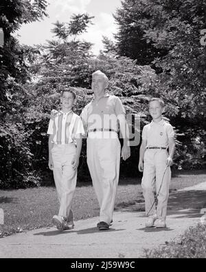 1960s MAN GRANDFATHER WALKING IN PARK WITH HIS TWO BOYS GRANDSONS - j11402 HAR001 HARS BROTHER OLD FASHION 1 FITNESS JUVENILE COMMUNICATION HEALTHY GRANDFATHER GRANDPARENTS FAMILIES JOY LIFESTYLE ELDER GRANDPARENT BROTHERS HEALTHINESS HOME LIFE COPY SPACE FULL-LENGTH PERSONS INSPIRATION CARING MALES SIBLINGS SPIRITUALITY SENIOR MAN SENIOR ADULT B&W ACTIVITY HAPPINESS PHYSICAL OLD AGE WELLNESS OLDSTERS OLDSTER HIS STRENGTH GRANDSONS LEADERSHIP LOW ANGLE RECREATION PRIDE AUTHORITY GRANDMOTHERS SIBLING ELDERS GRANDFATHERS CONCEPTUAL FLEXIBILITY GRANDSON MUSCLES STYLISH GROWTH JUVENILES PRE-TEEN Stock Photo