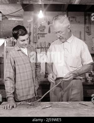 1950s 1960s TEENAGE BOY GRANDSON IN WORKSHOP WITH SENIOR MAN HIS GRANDFATHER DISCUSSING A GRAFTED ROOTED SAPLING FOR THE GARDEN - j11750 HAR001 HARS JUVENILE COMMUNICATION TEAMWORK INFORMATION GRANDFATHER RELAXING GRANDPARENTS JOY LIFESTYLE ELDER GRANDPARENT SHOWING RURAL HOME LIFE NATURE COPY SPACE FRIENDSHIP HALF-LENGTH PERSONS INSPIRATION MALES TEENAGE BOY SENIOR MAN SENIOR ADULT AGRICULTURE B&W GOALS SUCCESS SKILL ACTIVITY AMUSEMENT HAPPINESS OLD AGE OLDSTERS OLDSTER DISCUSSING HIS HOBBY INTEREST HOBBIES KNOWLEDGE RECREATION PASTIME INNOVATION PRIDE PLEASURE A IN THE AUTHORITY ELDERS Stock Photo