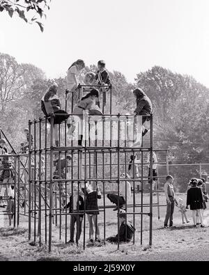 1960s 1970s DIVERSE GROUP OF KIDS BOYS AND GIRLS AT RECESS FROM SCHOOL CLIMBING ON JUNGLE GYM HANGING FROM MONKEY BARS - j12727 HAR001 HARS FULL-LENGTH PHYSICAL FITNESS PERSONS MALES B&W BARS FREEDOM GOALS SCHOOLS GRADE LEISURE AFRICAN-AMERICANS AFRICAN-AMERICAN AND EXCITEMENT RECESS RECREATION BLACK ETHNICITY PRIMARY FRIENDLY COOPERATION GRADE SCHOOL GROWTH RELAXATION TOGETHERNESS BLACK AND WHITE CAUCASIAN ETHNICITY HAR001 OLD FASHIONED AFRICAN AMERICANS Stock Photo