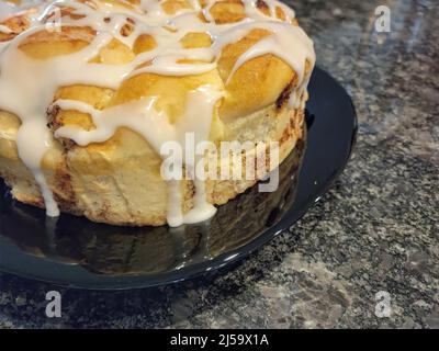 Close up of dripping white icing on homemade cinnamon rolls Stock Photo
