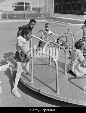 1970s 1980s GROUP OF DIVERSE BOYS AND GIRLS PLAYING ON A PLAYGROUND SPINNING MERRY-GO-ROUND - j13673 HAR001 HARS FITNESS PUSH JUVENILE STYLE DIVERSE HEALTHY SAFETY TEAMWORK DIFFERENT JOY LIFESTYLE FEMALES SPINNING COPY SPACE FRIENDSHIP HALF-LENGTH PERSONS MALES B&W ACTIVITY HAPPINESS PHYSICAL NEIGHBORHOOD HIGH ANGLE STRENGTH AFRICAN-AMERICANS AFRICAN-AMERICAN AND EXCITEMENT RECREATION BLACK ETHNICITY MERRY-GO-ROUND CONCEPTUAL SCHOOL YARD FLEXIBILITY MUSCLES VARIOUS VARIED COOPERATION GROWTH JUVENILES TOGETHERNESS BLACK AND WHITE CAUCASIAN ETHNICITY HAR001 OLD FASHIONED SPIN AFRICAN AMERICANS Stock Photo