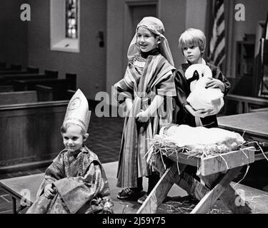 1970s THREE KIDS IN SUNDAY SCHOOL CHRISTMAS PAGEANT WITH BABY JESUS IN MANGER AND THREE WISE MEN BRINGING GIFTS - j14543 HAR001 HARS CELEBRATION FEMALES SUNDAY BETHLEHEM COPY SPACE FULL-LENGTH HALF-LENGTH PERSONS INSPIRATION WISE MALES CHRISTIAN ENTERTAINMENT CONFIDENCE GIFTS B&W HAPPINESS PERFORMER RELIGIOUS ROBES MERRY AND TRADITION IN ENTERTAINER MANGER BEARING DECEMBER BRINGING PAGEANT CONCEPTUAL DECEMBER 25 MAGI ACTORS FRANKINCENSE FAITHFUL MYRRH ENTERTAINERS FAITH GROWTH JOYOUS JUVENILES PERFORMERS TOGETHERNESS BELIEF BIBLICAL BLACK AND WHITE CAUCASIAN ETHNICITY HAR001 KINGS Stock Photo