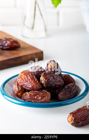 Dried dates in the bowl on white background. Stock Photo