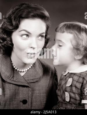 1950s LITTLE GIRL WHISPERING IN HER MOTHER’S EAR TELLING A SECRET AND MOTHER MAKING A FACE IN REACTION - j6240 HAR001 HARS NOSTALGIA OLD FASHION 1 JUVENILE FACIAL COMMUNICATION YOUNG ADULT INFORMATION LIFESTYLE PARENTING FEMALES STUDIO SHOT HOME LIFE COPY SPACE REPORT HALF-LENGTH LADIES DAUGHTERS PERSONS EXPRESSIONS B&W BRUNETTE BUZZ DISCOVERY AND KNOWLEDGE BUSYBODY TELLING STORIES CONCEPTUAL STYLISH INFORM TATTLER HEARSAY GROWTH JUVENILES MOMS MOTHER'S REACTION RUMORS TATTLE TOGETHERNESS YOUNG ADULT WOMAN BLACK AND WHITE CAUCASIAN ETHNICITY HAR001 OLD FASHIONED Stock Photo