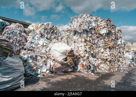 Heaps of waste paper, cardboard, newspapers and other paper waste folded for recycling. Reuse paper to save trees and ecology concept. Stock Photo