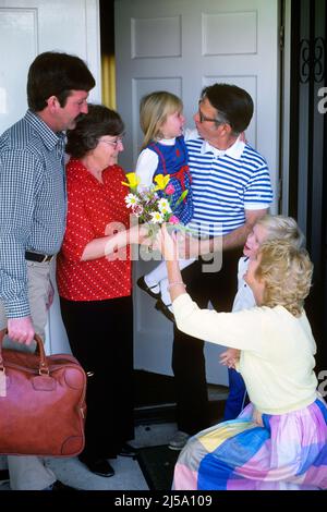 1980s FAMILY AT FRONT DOOR VISITING RELATIVES MAN HOLDING GRANDDAUGHTER WOMAN HANDING BOUQUET OF FLOWERS TO GRANDMOTHER - kj9871 RES001 HARS 4 SUBURBAN COLOR DOORWAY RELATIONSHIP MOTHERS SENIORS GRANDMOTHER OLD TIME NOSTALGIA OLD FASHION 1 BOUQUET JUVENILE WELCOME COMMUNICATION GENERATIONS GRANDFATHER SONS FAMILIES JOY LIFESTYLE PARENTING CELEBRATION ELDER FEMALES GRANDPARENT RELATION HUSBANDS HOME LIFE 6 COPY SPACE PEOPLE CHILDREN FRIENDSHIP FULL-LENGTH HALF-LENGTH DAUGHTERS PERSONS CARING MALES SIX SENIOR MAN SENIOR ADULT DOORWAYS FATHERS HUSBAND AND WIFE PATERNAL PARENT AND CHILD Stock Photo