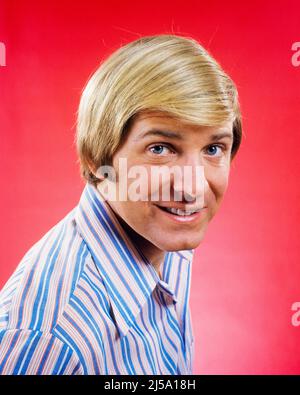 1960s 1970s PORTRAIT OF SMILING BLONDE MAN WITH LONGISH BLONDE HAIRSTYLE LOOKING AT CAMERA WEARING A BLUE & WHITE STRIPED SHIRT - kp1900 HAR001 HARS STRIPES EYE CONTACT HAPPINESS HEAD AND SHOULDERS CHEERFUL STYLES HAIRSTYLE SMILES JOYFUL STYLISH HUTCH FASHIONS MID-ADULT MID-ADULT MAN CAUCASIAN ETHNICITY COMB OVER HAR001 OLD FASHIONED Stock Photo