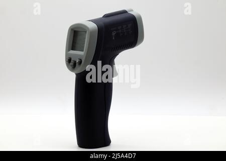 Infrared laser thermometer isolated on white. It measures temperature without contact. Stock Photo