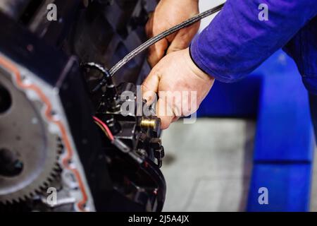 Industrial worker assembles machine, close up. Stock Photo