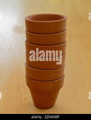 Clean, brown terracotta pots are in a stack waiting to be potted up. Stock Photo