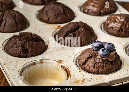 fresh baked muffins with chocolate cream and blueberries in ceramic pan Stock Photo
