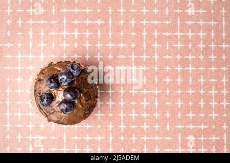 fresh baked muffin with chocolate cream and blueberries on the table copy space top view Stock Photo