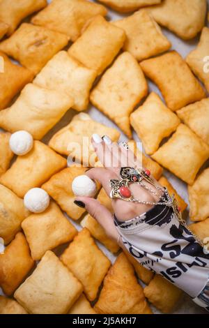 the hand of a girl with Kazakh national costume jewelry is held by Kurt. Stock Photo