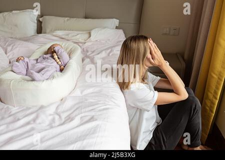 Tired Mother Suffering from experiencing postnatal depression. Health care mom motherhood stressful. Stay home during coronavirus covid-19 pandemic Stock Photo