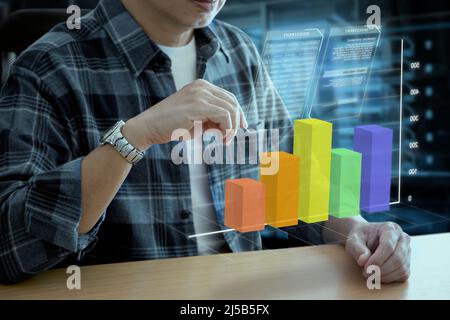 Man in casual cloth interacting with futuristic augmented reality virtual graph of business information and return on investment Stock Photo