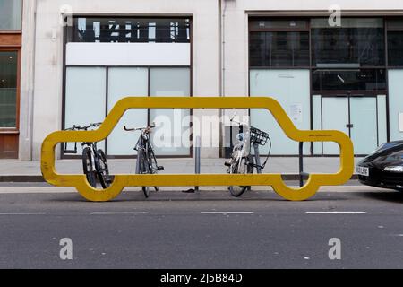 London, Greater London, England, April 09 2022: Bikes parked at a car shaped yellow Cycle Rack by Cyclehoop. Stock Photo