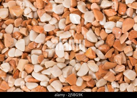 Small orange and white wet pebble stone floor background texture. Stock Photo