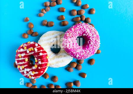Donut with hazelnuts on a blue background, close up Stock Photo