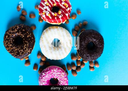 Donut with hazelnuts on a blue background, close up Stock Photo