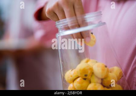 hand taking nastar pineapple cake in glass container Stock Photo