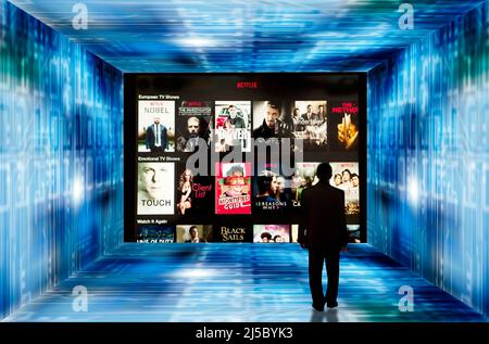 man in a room with Netflix screen on a wall Stock Photo