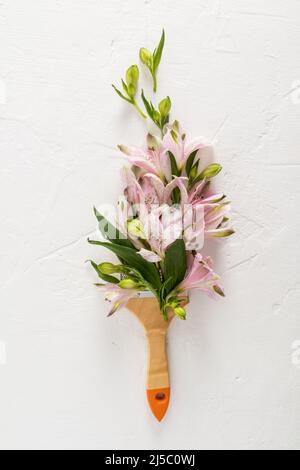 creative composition with flowers and brush. Spring is a time of change. paint life with different colors. white vertical background Stock Photo