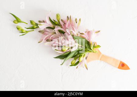 creative composition with flowers and brush. Spring is a time of change. paint life with different colors. white background Stock Photo