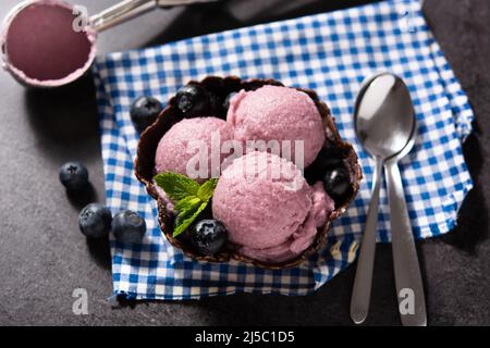 Blueberry ice cream scoop on black slate background Stock Photo