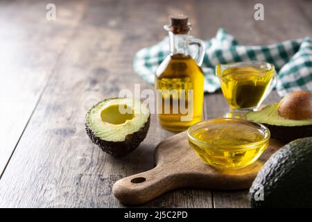 Oil and ripe fresh avocado on rustic wooden table Stock Photo