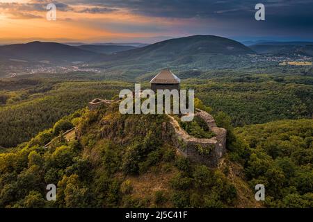Salgotarjan, Hungary - Aerial view of Salgo Castle (Salgo vara) in Nograd county with dark storm clouds and golden sunset sky on a summer afternoon Stock Photo
