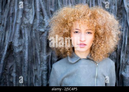 closeup young latin woman with curly afro hair outdoors with soft light Stock Photo