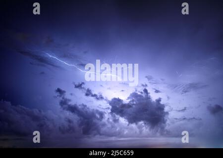 Thunderstorm above Cagliari, Sardinia, Italy. Lightning behind some clouds. Stock Photo