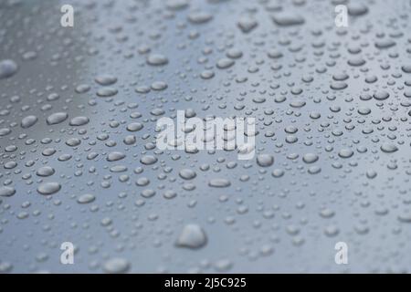 Raindrops on black hood of car closeup Stock Photo