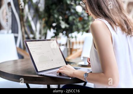 image of a young woman using a laptop to work with documents. Stock Photo