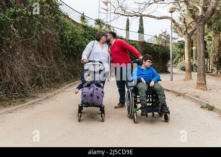 A happy and loving family walking with their children in the park Stock Photo