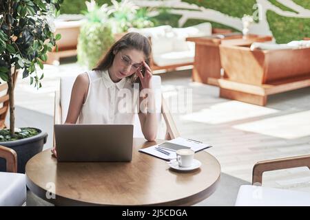 thoughtful business woman sitting at a table in a cozy cafe. Stock Photo