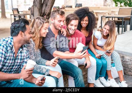 Young student friends group using smartphone with coffee at university college - People addicted by mobile smart phones - Technology concept with alwa Stock Photo