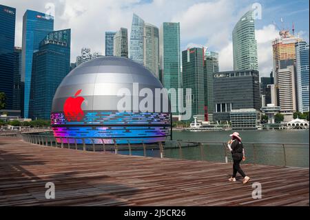 Aug. 28, 2020, Singapore, Republic of Singapore, Asia - A woman walks past the new Apple flagship store on the waterfront in Marina Bay Sands, with the business district skyline in the background. The building's futuristic architecture takes the form of a giant sphere floating on the water and is the third Apple store in the Southeast Asian city-state. [automated translation] Stock Photo