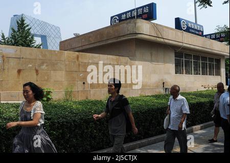 16.08.2012, Beijing, China, Asia - People walk past in the business center at Guomao subway station in the Chinese capital, while the new building of CCTV Headquarters can be seen in the background. [automated translation] Stock Photo