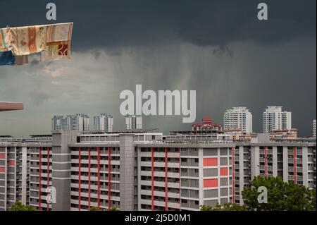 12.03.2021, Singapore, Republic of Singapore, Asia - Dark rain clouds with precipitation over high-rise buildings of a residential area in the Ang Mo Kio district. [automated translation] Stock Photo