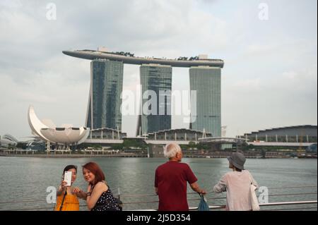 May 12, 2019, Singapore, Republic of Singapore, Asia - Tourists on the Jubilee Bridge on the banks of the Singapore River in Marina Bay with the three skyscraper towers of the Marina Bay Sands Hotel and the ArtScience Museum in the background. [automated translation] Stock Photo