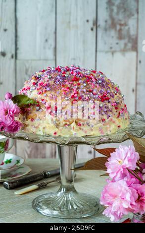 Dome cake - filled with fruity jelly, dark chocolate mousse and raspberry puree, covered with white chocolate ganache and decorated with colorful spri Stock Photo