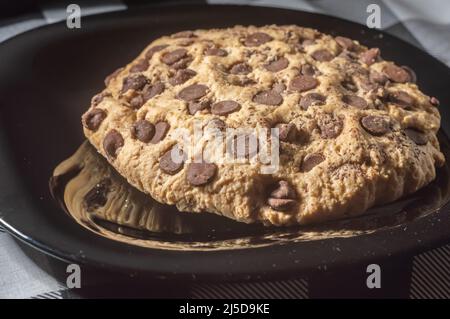 Big cookie with chocolate drops with natural light,homemade recipe concept. Stock Photo