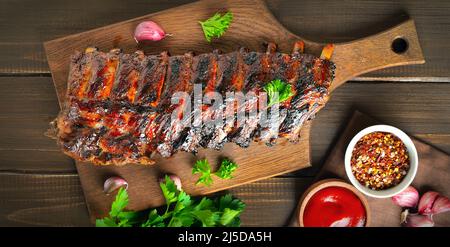 Grilled pork ribs on cutting board. Top view, flat lay. Stock Photo