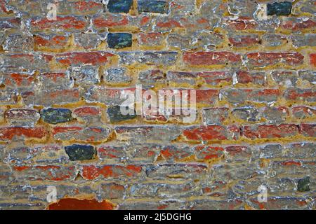 Closeup of isolated old medieval brick stone wall with faded pale washed out red grey colors Stock Photo