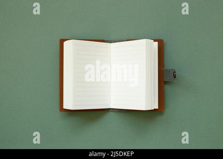 Blank notebook on green background. top view, copy space Stock Photo